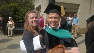 image of Thomas holding Sarah at his graduation with cap and gown