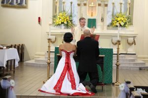 Image of Claudia and Donald kneeling in front of the altar on their wedding day