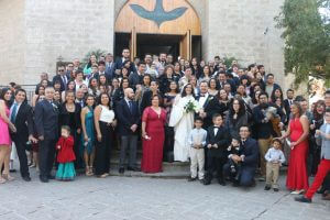 Image of wedding guests and couple in front of church
