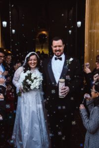 Image of couple exiting church surrounded by bubbles