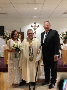 Image of couple with priest on their wedding day