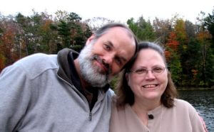 Image of Paul and Rose smiling outside by trees