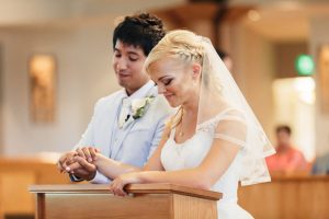 Image of bride and groom holding hands in prayer