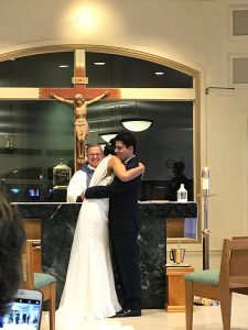 Image of couple in wedding attire hugging each other on wedding day