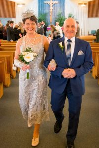Image of couple leaving church on wedding day arm in arm