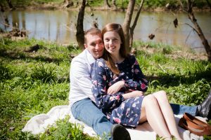 Image of couple sitting on picnic blanket near water