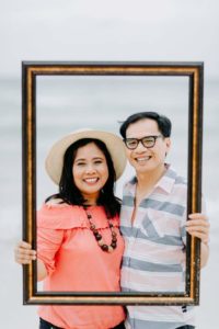 Image of couple holding picture frame and smiling