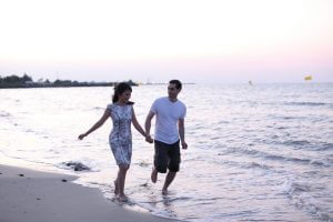 Image of couple holding hands along the beach.