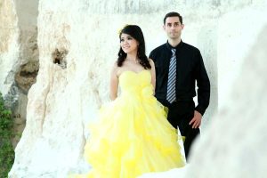 Image of couple standing in formal wear near large white rocks