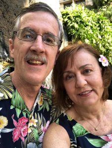 Image of couple in flower shirts near greenery
