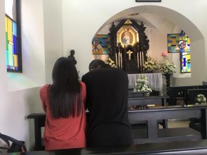 Image of couple kneeling in prayer in front of tabernacle