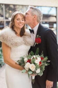 Image of groom kissing bride on the cheek