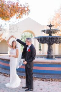 Image of groom dancing with bride near fountain outside