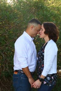 Image of couple with foreheads together near a tree