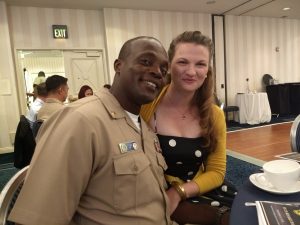 Image of couple smiling at the camera sitting inside
