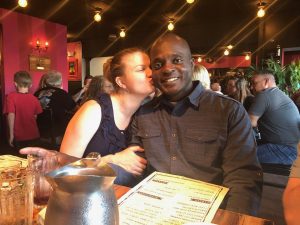 Image of woman kissing man on the cheek at a restaurant