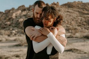 man and woman hugging in desert